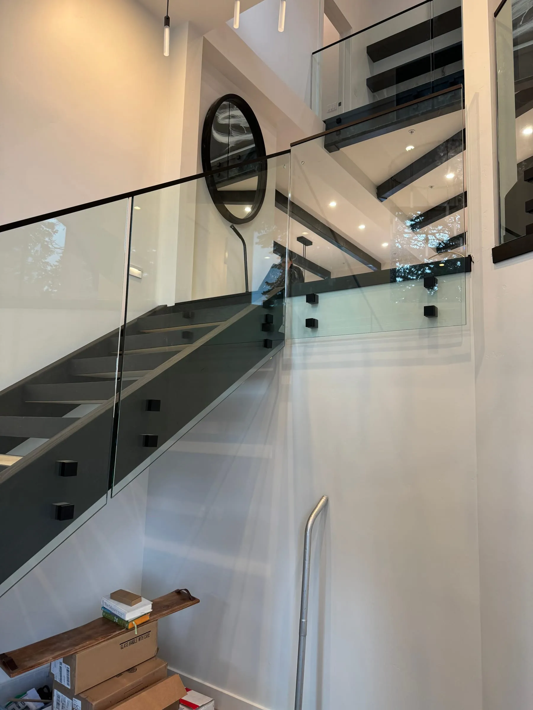 Glass loft railing with black trim under a high ceiling