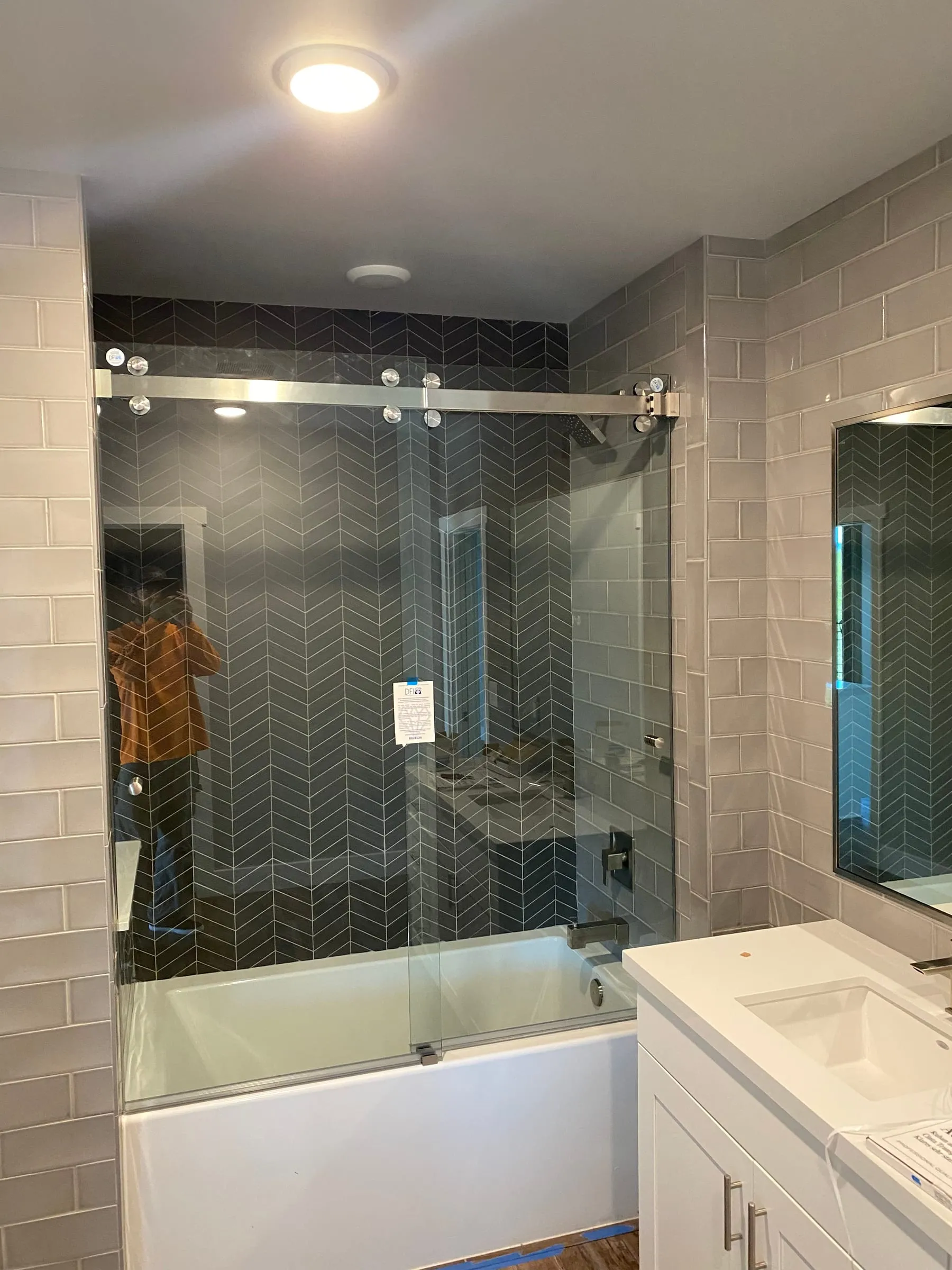 Frameless sliding glass door over a bathtub